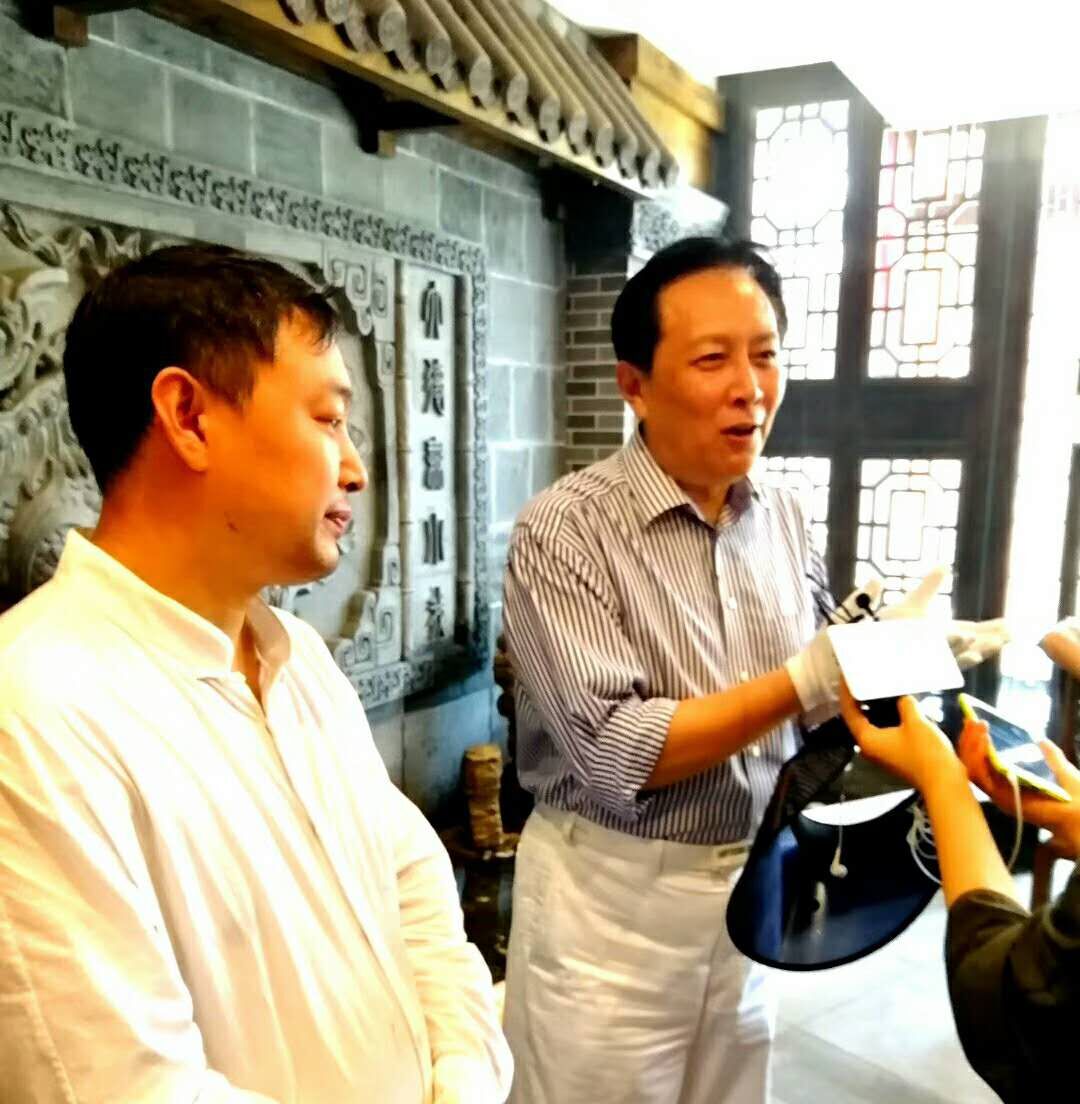 上图，乔领、宁雪君崂山美术馆展览之际，乔领与著名演员唐国强先生，接受媒体采访。
