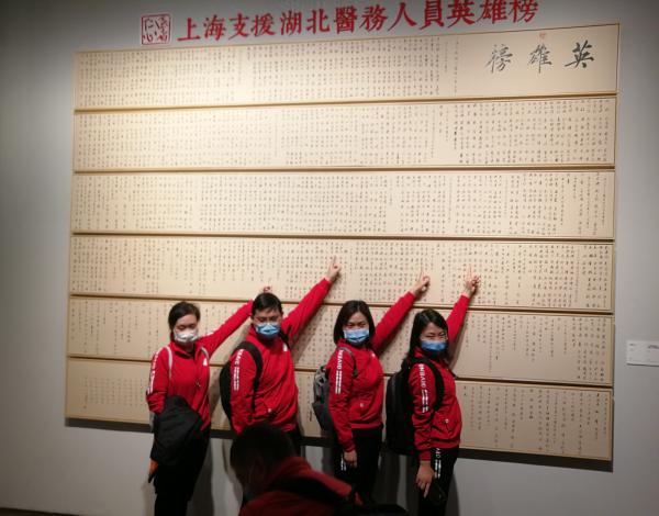 “召唤——上海市抗击新冠肺炎疫情美术、摄影主题展”上,上海援鄂医疗队成员在书法《上海支援湖北医务人员英雄榜》中指着自己的名字